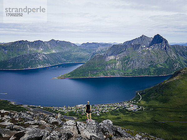 Wanderer  der die Aussicht betrachtet  während er auf einem Berg in Segla  Norwegen  steht