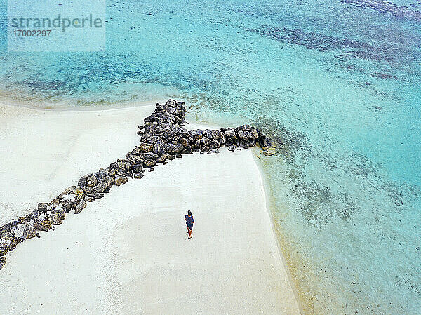 Malediven  Kaafu Atoll  Luftaufnahme eines Mannes  der allein am Sandstrand der Insel Huraa steht