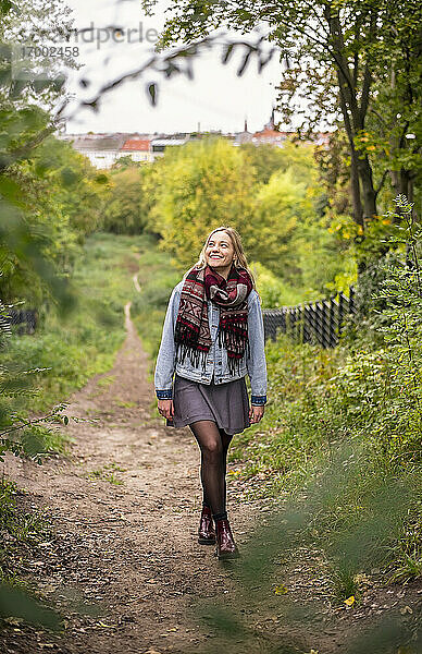 Junge Frau geht im Herbst im Park spazieren