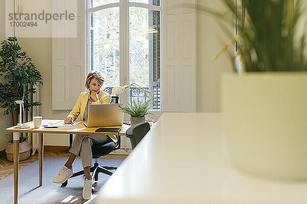 Weiblicher Ingenieur arbeitet an einem Laptop  während er im Büro sitzt