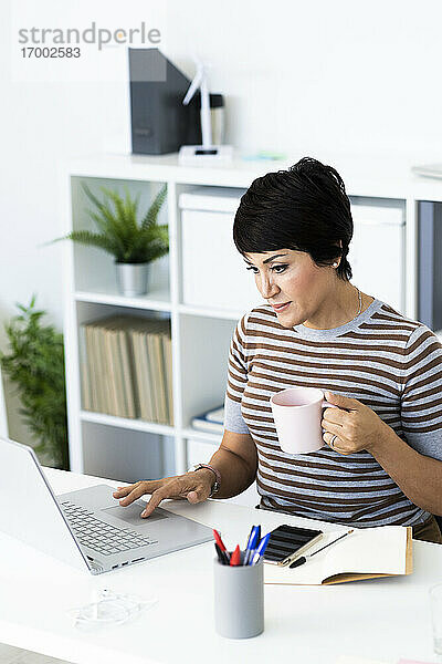 Porträt einer Geschäftsfrau mit Laptop am Bürotisch