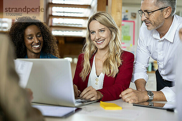 Geschäftsleute lächelnd während der Arbeit in der Sitzung zusammen im Büro