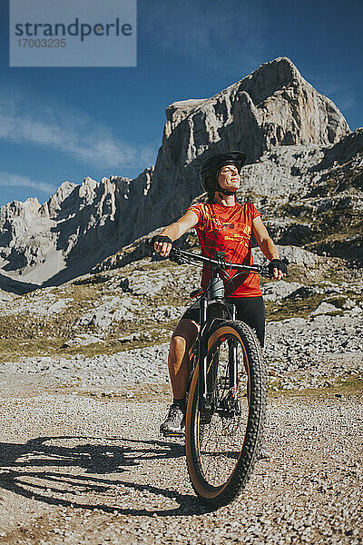 Lächelnde Radfahrerin mit geschlossenen Augen auf dem Fahrrad im Nationalpark Picos de Europa  Kantabrien  Spanien