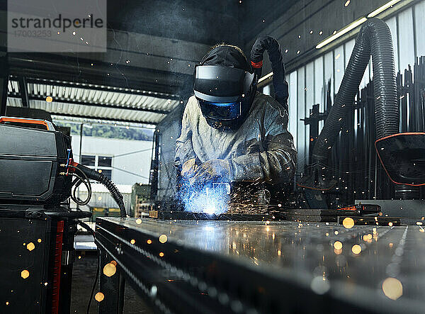 Metallarbeiter in Arbeitsschutzkleidung beim Schweißen von Metall in einer Fabrik
