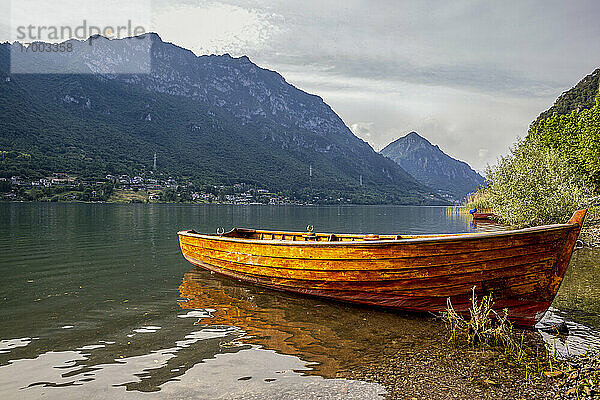 Boot am Seeufer gegen einen Berg an einem sonnigen Tag