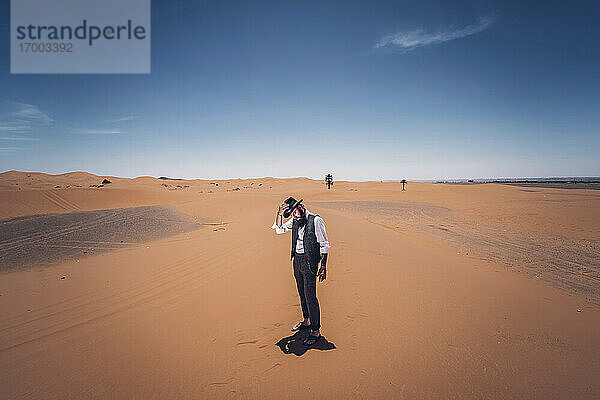 Mann mit Bart und Hut in den Dünen der Wüste von Marokko