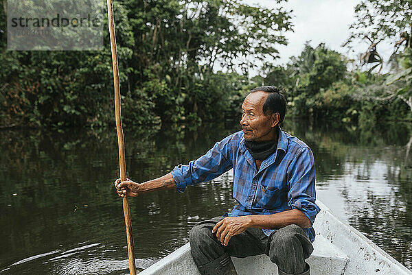 Älterer Guarani-Mann sitzt im Kanu auf dem Napo-Fluss  Ecuador