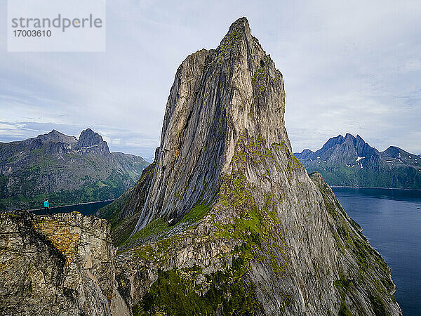 Stehende Frau  die die Aussicht auf den Berg Segla in Norwegen bewundert