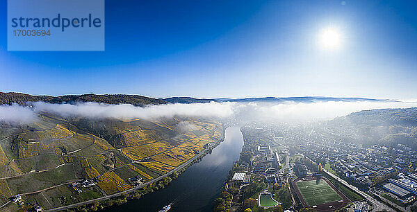 Deutschland  Rheinland-Pfalz  Bernkastel-Kues  Blick aus dem Hubschrauber auf die Stadt am Fluss und die Weinberge am Hang an einem nebligen Herbstmorgen