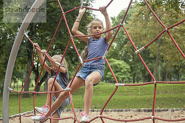 Mädchen klettern auf dem Klettergerüst auf dem Spielplatz