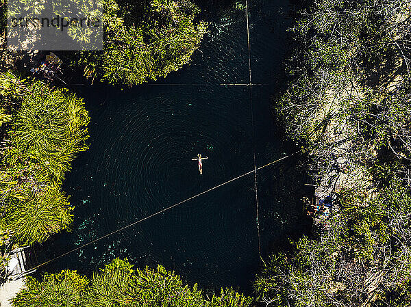 Luftaufnahme einer Frau beim Schwimmen in einer Cenote
