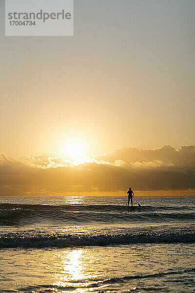 Silhouette Frau Surfen mit Paddleboard auf dem Mittelmeer in der Morgendämmerung