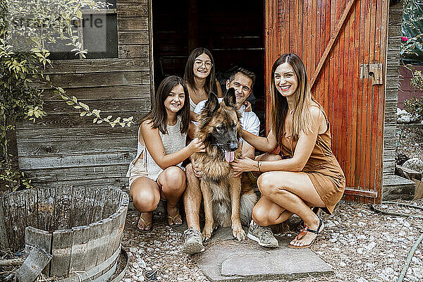 Lächelnde Familie mit Hund im Hinterhof
