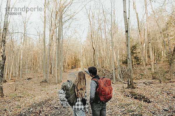 Junges Paar bei Herbstwanderung im Wald stehend
