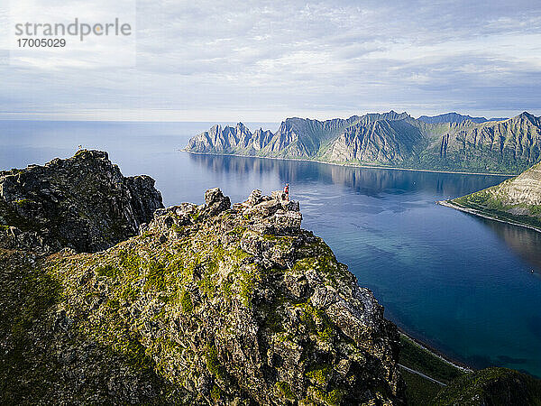 Frau steht auf einem Berg am Husfjellet  Senja  Norwegen
