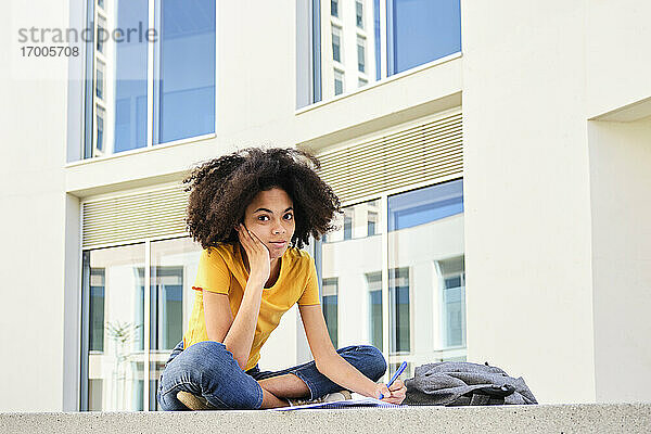 Studentin studiert sitzend auf dem Universitätscampus