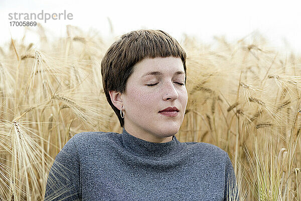 Frau träumt vor einem Getreidefeld