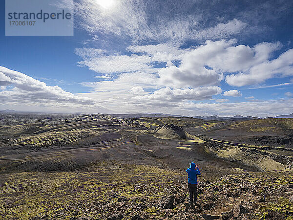 Mann betrachtet die Landschaft  während er an einem sonnigen Tag auf einem Felsen steht  Lakagigar  Island