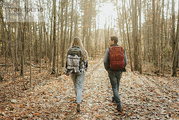 Junges Paar beim Wandern mit Rucksäcken im Herbstwald