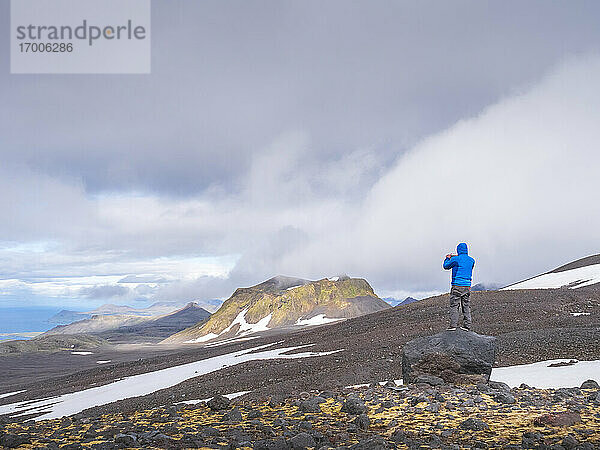 Männlicher Wanderer steht auf einem Felsen im Snaefellsjokull Nationalpark  Island