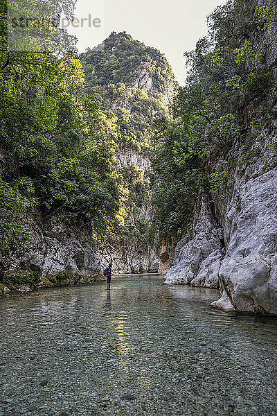 Mann steht im Fluss Acheron am Berg in Epirus  Griechenland