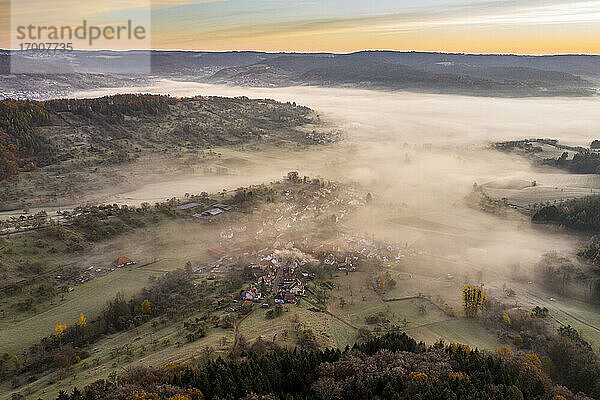 Drohnenansicht des morgendlichen Nebels  der das Dorf im Wieslauftal einhüllt