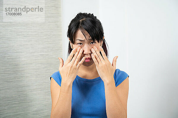 Asiatische Frau mit Nasennebenhöhlenentzündung.