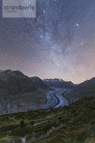 Glühende Sterne und Milchstraße am Nachthimmel über dem Aletschgletscher  Berner Alpen  Kanton Wallis  Schweiz  Europa