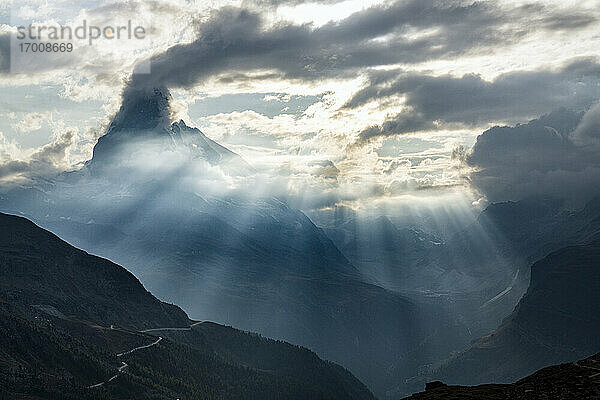Sonnenstrahlen durch Wolken über dem Matterhorn während eines beleuchteten Sonnenuntergangs  Zermatt  Kanton Wallis  Schweiz  Europa