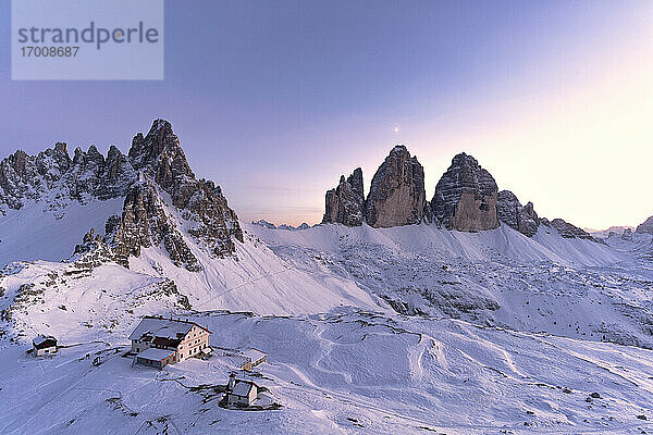 Sonnenuntergang über dem Monte Paterno  den Drei Zinnen und der verschneiten Locatelli-Hütte  Sextner Dolomiten  Südtirol  Italien  Europa