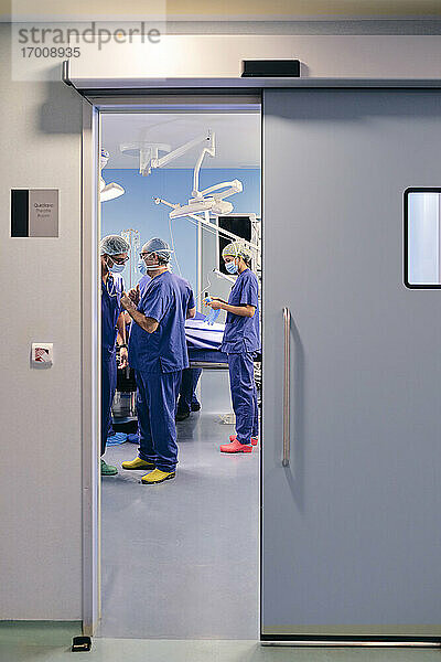 Ärzte mit Gesichtsmaske führen eine Diskussion im Operationssaal eines Krankenhauses