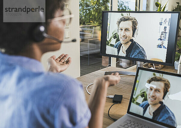 Frau hält Videokonferenz mit Mann über Laptop zu Hause