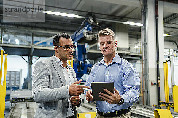 Erfahrener Manager und Vorgesetzter  der in der Industrie an einem digitalen Tablet arbeitet