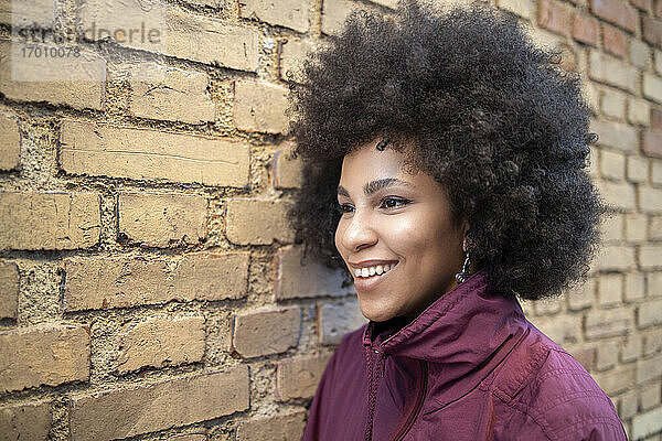 Glückliche Afro-Frau  die von der Mauer wegschaut
