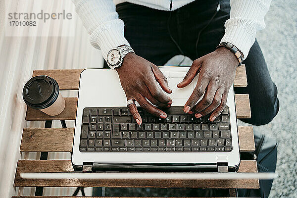 Junger Mann mit Laptop in einem Café sitzend