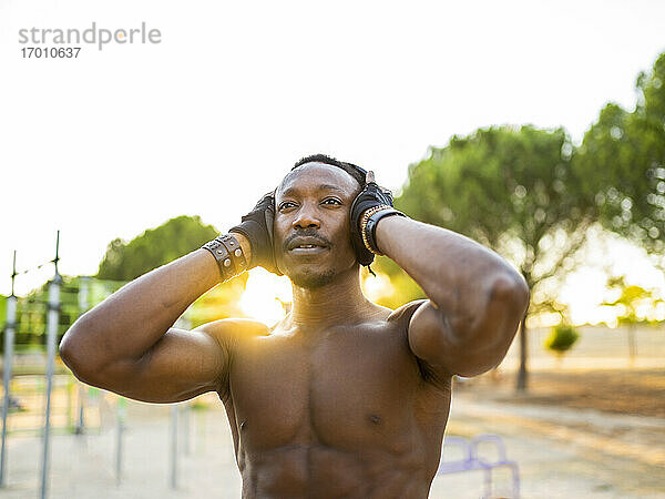 Sportler mit Kopfhörern  der Musik hört  während er im Park steht