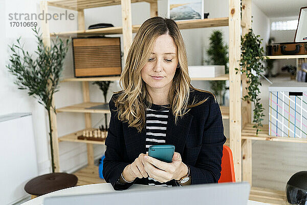 Geschäftsfrau benutzt Smartphone im Büro