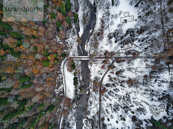 Luftaufnahme einer Landstraße  die sich durch eine schneebedeckte Landschaft zieht