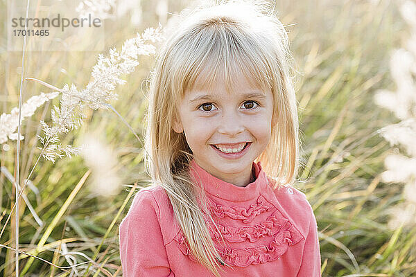 Lächelndes süßes Mädchen in landwirtschaftlichem Feld