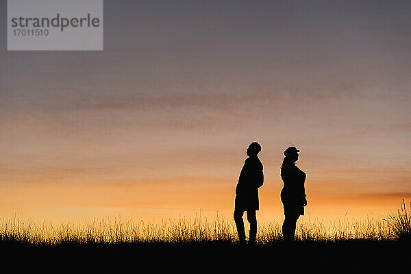 Silhouette eines Mannes und einer Frau  die vor dem Himmel stehen