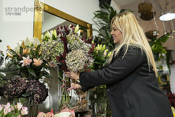 Floristin arrangiert Blumen im Blumenladen