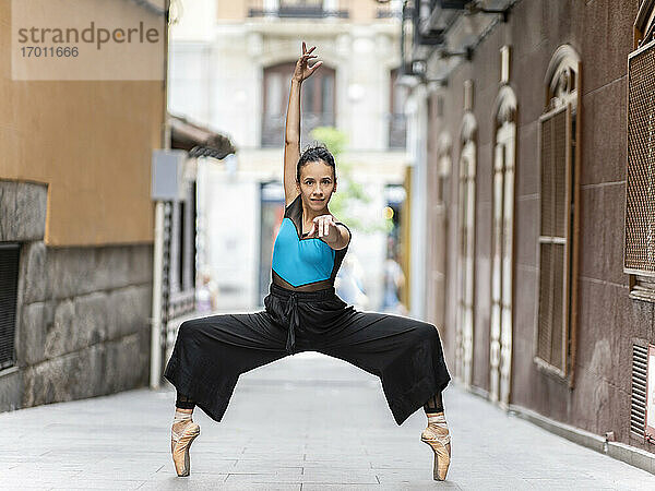Leidenschaftliche Balletttänzerin tanzt auf Zehenspitzen auf dem Fußweg stehend