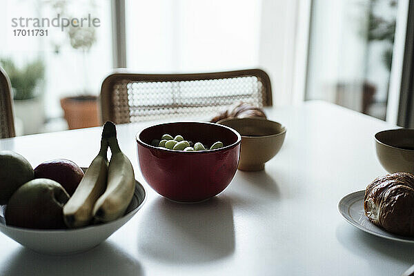 Früchte und Croissant in einer Schale auf dem Esstisch in der Wohnung