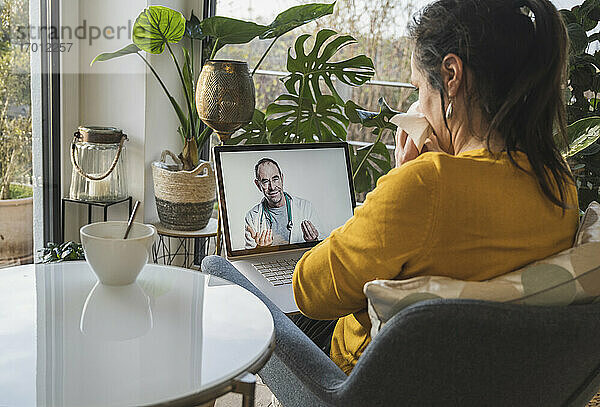 Frau berät sich mit Arzt während eines Videogesprächs auf dem Laptop