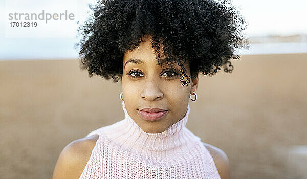 Nahaufnahme eines Porträts einer jungen Frau mit Afro-Haar am Strand