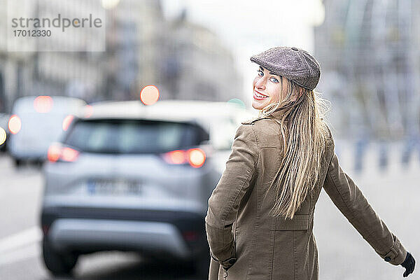 Schöne Frau schaut über die Schulter  während sie auf der Straße steht