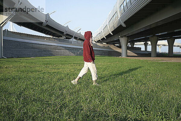 Junge Frau geht über Gras in einem Feld