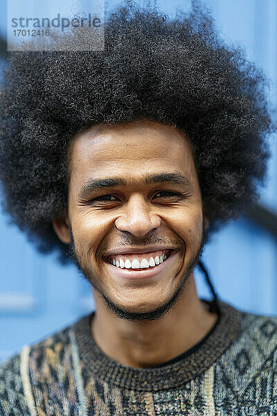 Close-up-Porträt eines lächelnden jungen Mannes mit lockigem Haar