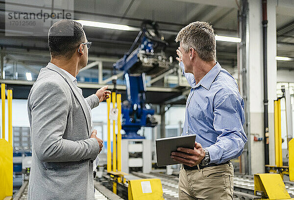 Manager und Vorgesetzter diskutieren über Maschinen in der Fabrik