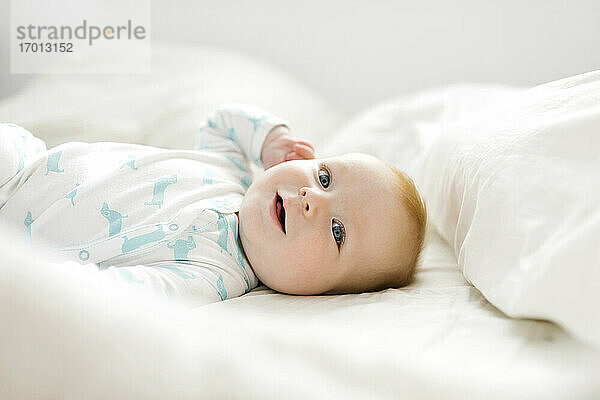 Baby-Junge (6-11 Monate) auf dem Bett liegend